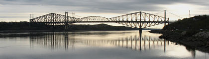 Side view of the Québec Bridge at dawn.